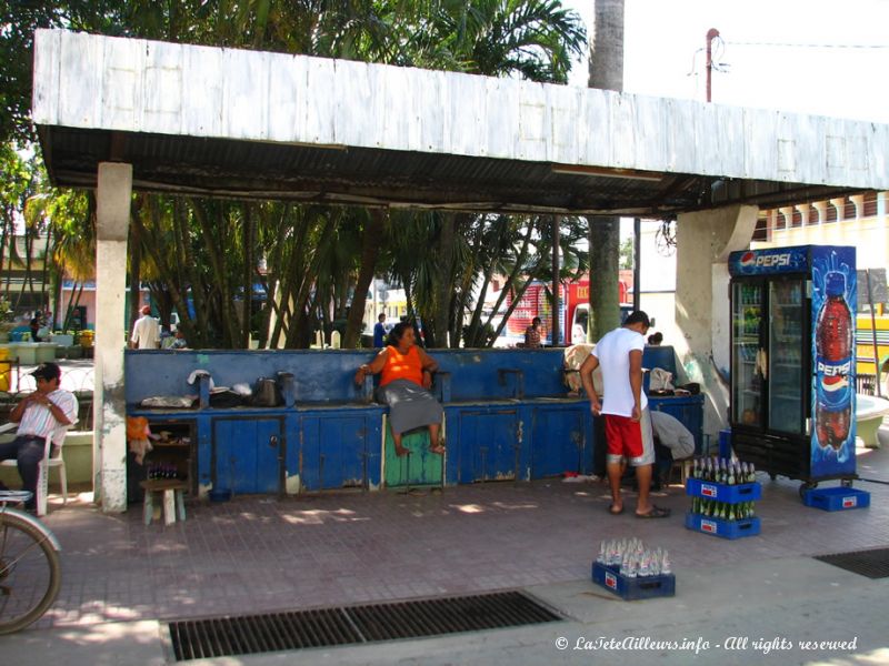 Au bord de la place, un stand de cirage de chaussures