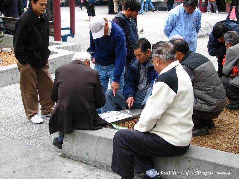 Des parties de dames chinoises se jouent sur les places de Chinatown