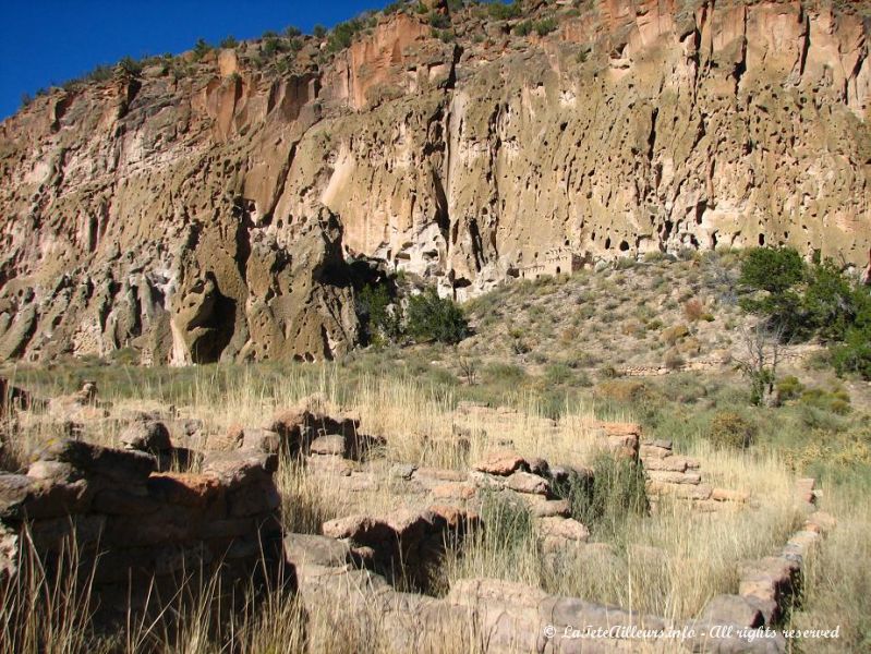 Les ruines d'un ancien village anasazi devant la falaise elle aussi habitee