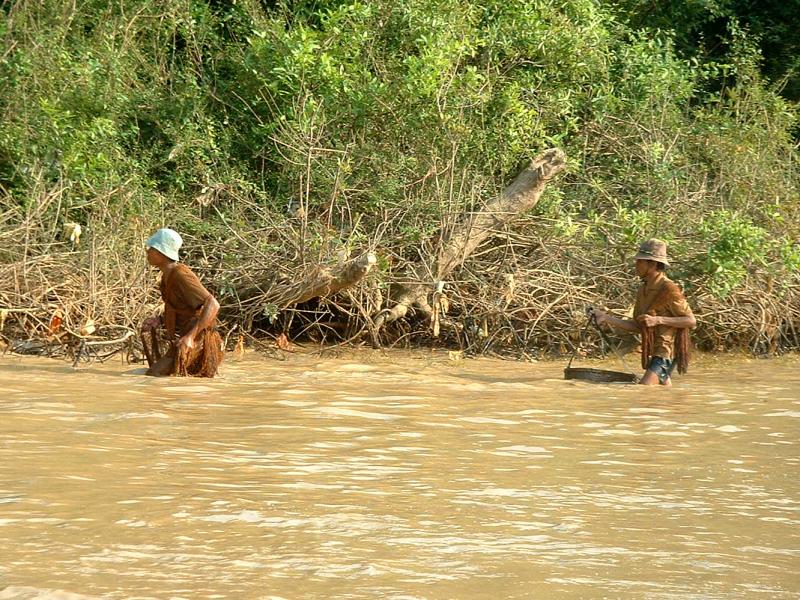 Les pêcheurs s'aventurent tout habillés dans l'eau boueuse