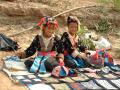 Dans leurs habits traditionnels, deux jeunes filles apâtent les touristes